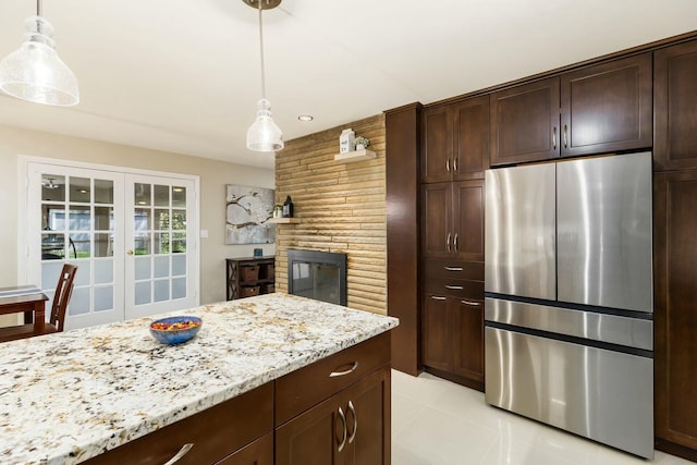 144 Serran Dr, Gahanna, OH 43230 - kitchen with french doors, dark brown cabinets, freestanding refrigerator, light stone counters, and hanging light fixtures