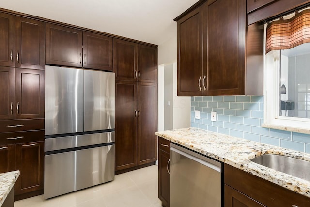 144 Serran Dr, Gahanna, OH 43230 - kitchen with light tile patterned flooring, light stone countertops, decorative backsplash, and stainless steel appliances