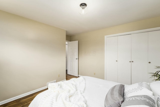 144 Serran Dr, Gahanna, OH 43230 - bedroom with baseboards, dark wood-style floors, and a closet