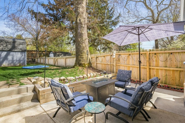 144 Serran Dr, Gahanna, OH 43230 - view of patio / terrace with an outdoor fire pit, a fenced backyard, an outdoor structure, and a storage shed