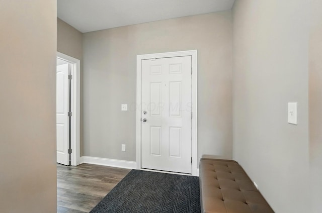 doorway to outside featuring baseboards and wood finished floors