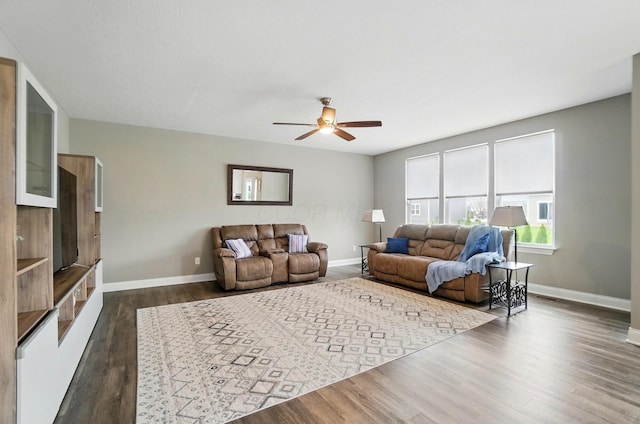 living area featuring dark wood-style flooring, ceiling fan, visible vents, and baseboards