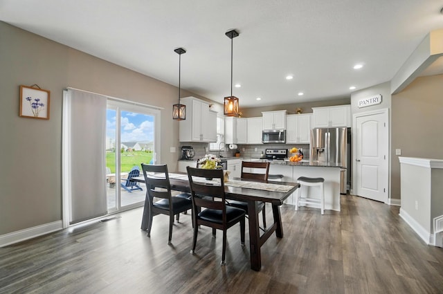 dining space with recessed lighting, dark wood-style flooring, and baseboards