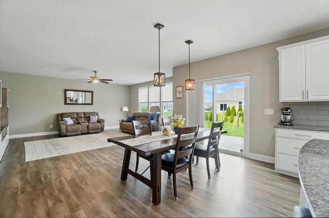 dining room with a ceiling fan, wood finished floors, and baseboards