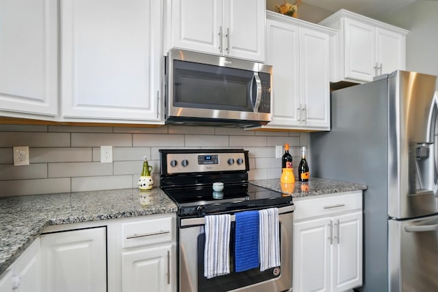 kitchen featuring appliances with stainless steel finishes, white cabinetry, and tasteful backsplash