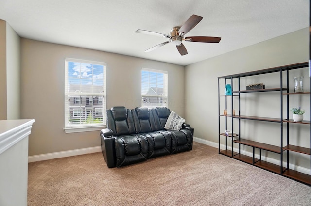 sitting room featuring a ceiling fan, carpet floors, and baseboards