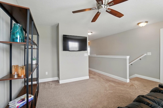 living room featuring a ceiling fan, carpet flooring, and baseboards