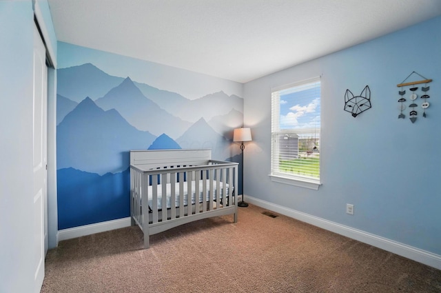 bedroom featuring baseboards, visible vents, a nursery area, and carpet