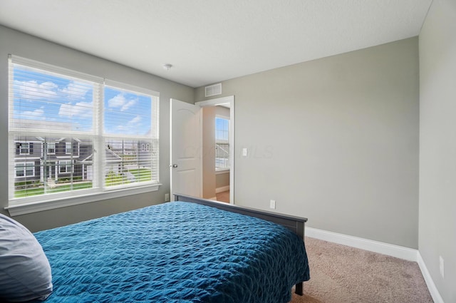 bedroom featuring visible vents, multiple windows, carpet floors, and baseboards