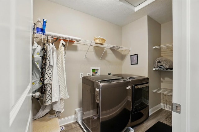 laundry area featuring attic access, washer and clothes dryer, laundry area, baseboards, and wood finished floors