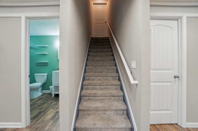 stairway featuring baseboards and wood finished floors