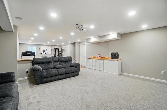 living room featuring recessed lighting, light colored carpet, and baseboards