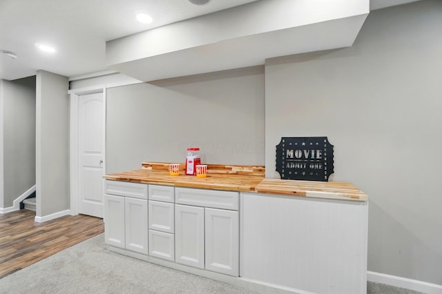 bar featuring carpet, recessed lighting, stairs, and baseboards