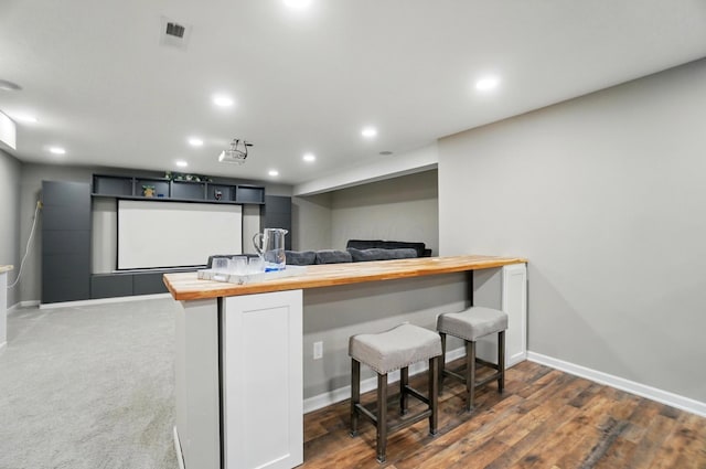 interior space featuring butcher block counters, visible vents, and baseboards