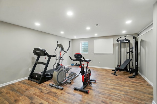 exercise area with recessed lighting, visible vents, wood finished floors, and baseboards