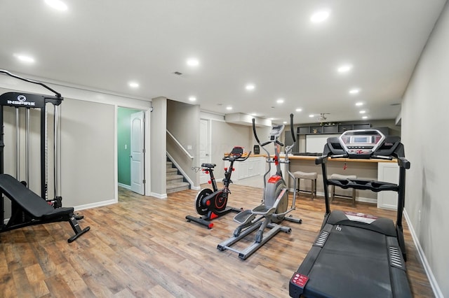 workout room with baseboards, recessed lighting, and wood finished floors