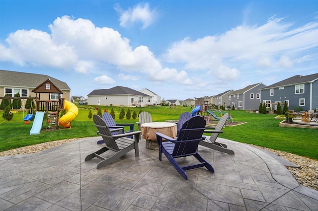view of patio / terrace featuring an outdoor fire pit, a residential view, and a playground