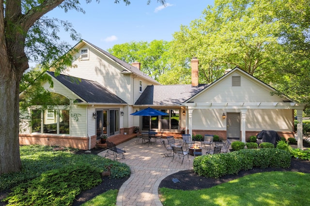 4318 Lyon Dr, Upper Arlington, OH 43220 - rear view of property featuring brick siding, an outdoor fire pit, a chimney, a patio, and a yard