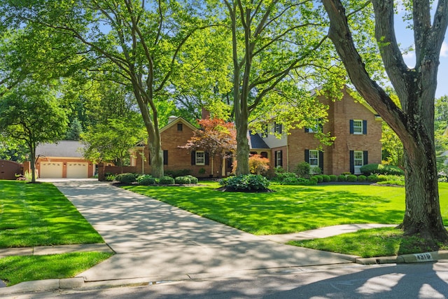 4318 Lyon Dr, Upper Arlington, OH 43220 - view of front facade featuring brick siding, driveway, a front lawn, and a garage