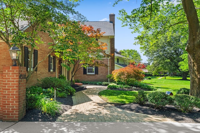 4318 Lyon Dr, Upper Arlington, OH 43220 - view of property hidden behind natural elements with brick siding, a chimney, and a front lawn