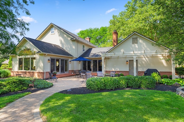 4318 Lyon Dr, Upper Arlington, OH 43220 - rear view of property with brick siding, a yard, a chimney, and a patio