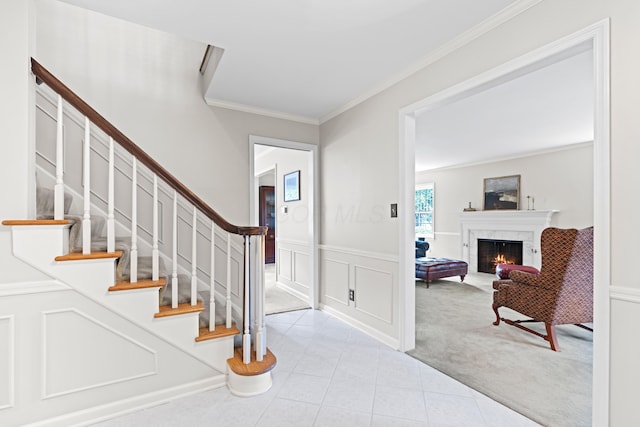 4318 Lyon Dr, Upper Arlington, OH 43220 - tiled foyer entrance featuring carpet, ornamental molding, a lit fireplace, stairs, and a wainscoted wall