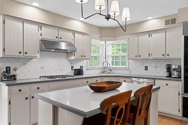 4318 Lyon Dr, Upper Arlington, OH 43220 - kitchen featuring stainless steel appliances, under cabinet range hood, a center island, backsplash, and recessed lighting