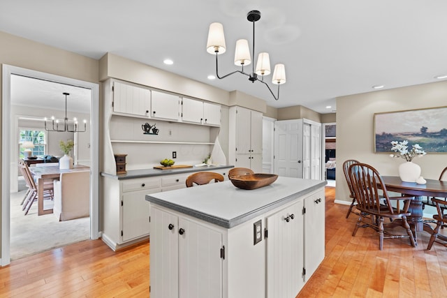 4318 Lyon Dr, Upper Arlington, OH 43220 - kitchen featuring a chandelier, light wood-style floors, open shelves, white cabinets, and a kitchen island