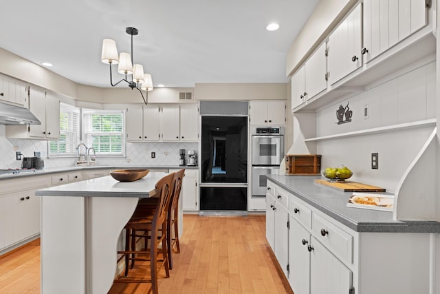 4318 Lyon Dr, Upper Arlington, OH 43220 - kitchen with stainless steel appliances, under cabinet range hood, backsplash, light wood finished floors, and recessed lighting