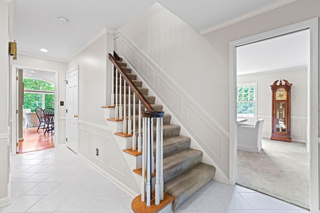 4318 Lyon Dr, Upper Arlington, OH 43220 - stairs featuring tile patterned flooring, a decorative wall, crown molding, a wainscoted wall, and carpet floors