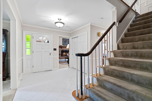 4318 Lyon Dr, Upper Arlington, OH 43220 - entryway with stairway, ornamental molding, light tile patterned flooring, a decorative wall, and a brick fireplace