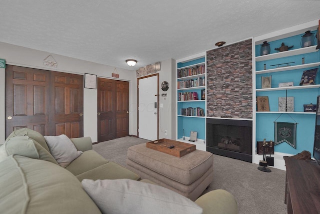 625 Country Club Dr Unit B14, Newark, OH 43055 - living area featuring a textured ceiling, carpet flooring, a stone fireplace, and built in shelves
