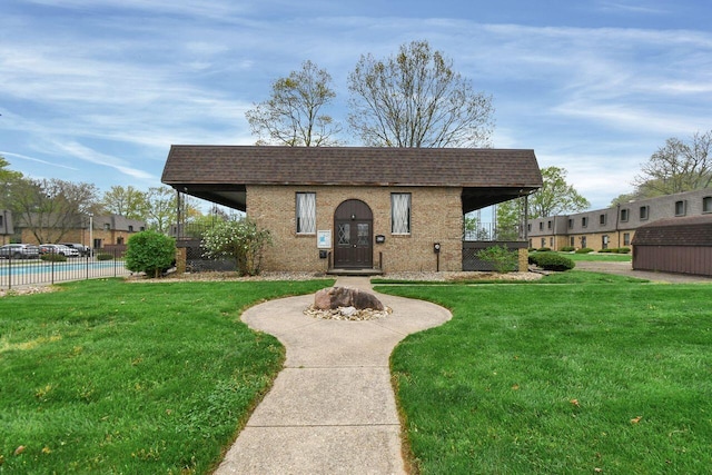 625 Country Club Dr Unit B14, Newark, OH 43055 - view of front of home featuring an outdoor structure, brick siding, a shingled roof, a fenced in pool, and a front yard