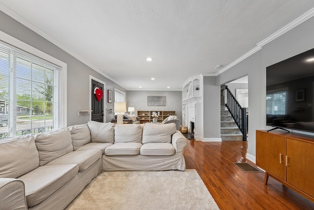 living area with a fireplace, wood finished floors, baseboards, ornamental molding, and recessed lighting