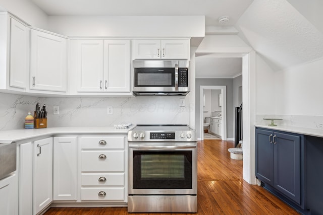 kitchen featuring light countertops, appliances with stainless steel finishes, white cabinets, and blue cabinetry