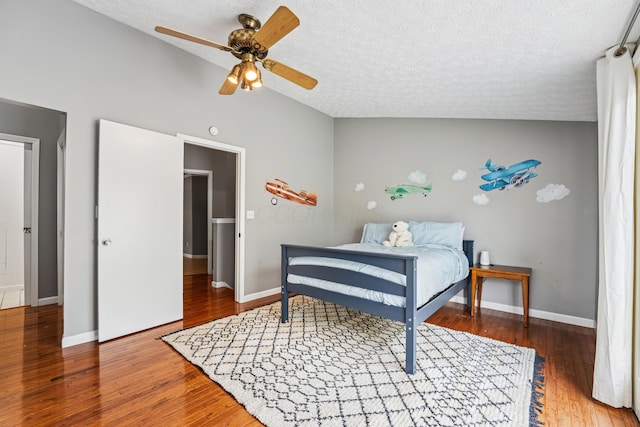 bedroom with a textured ceiling, baseboards, a ceiling fan, and wood finished floors