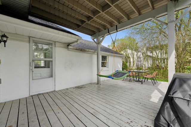 wooden terrace featuring outdoor dining space and a grill