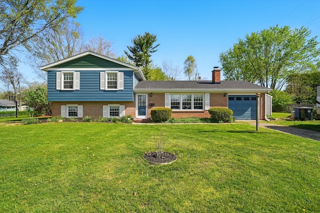 tri-level home with aphalt driveway, a chimney, an attached garage, a front lawn, and brick siding