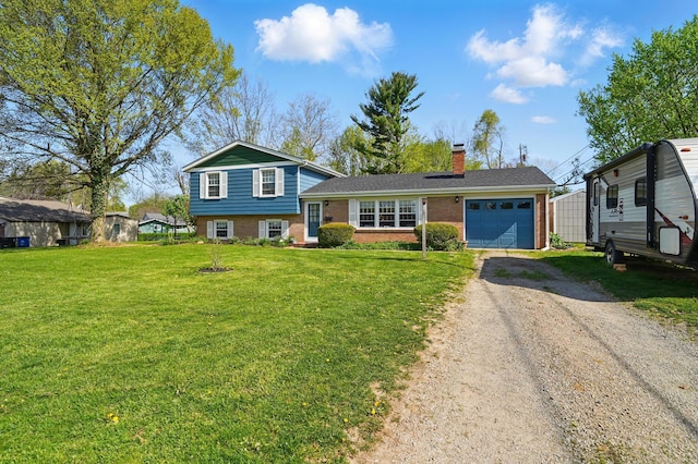 tri-level home featuring a front yard, brick siding, driveway, a chimney, and an attached garage