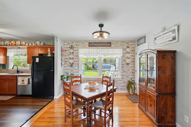 dining area featuring light wood finished floors and baseboards