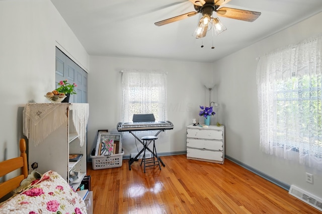bedroom featuring visible vents, ceiling fan, baseboards, a closet, and wood finished floors