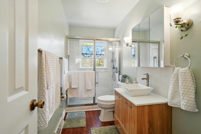 full bath with vanity, wood finished floors, toilet, and a stall shower