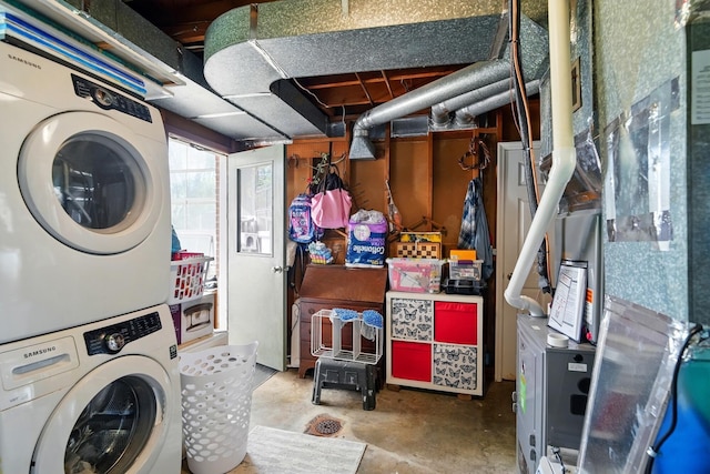 clothes washing area with stacked washer and clothes dryer and laundry area