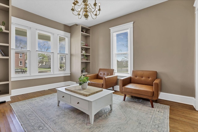 704 E High St, Mount Vernon, OH 43050 - sitting room featuring wood finished floors, a wealth of natural light, and a notable chandelier
