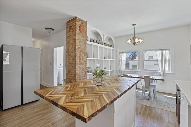 704 E High St, Mount Vernon, OH 43050 - kitchen with decorative light fixtures, a notable chandelier, light wood finished floors, and freestanding refrigerator