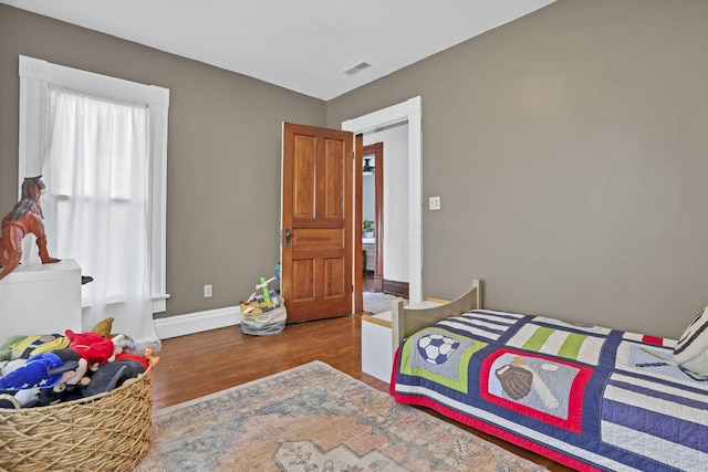 704 E High St, Mount Vernon, OH 43050 - bedroom with wood finished floors, visible vents, and baseboards