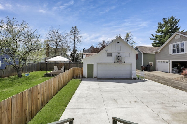 704 E High St, Mount Vernon, OH 43050 - view of front of home featuring board and batten siding, fence, an outbuilding, a front yard, and a garage