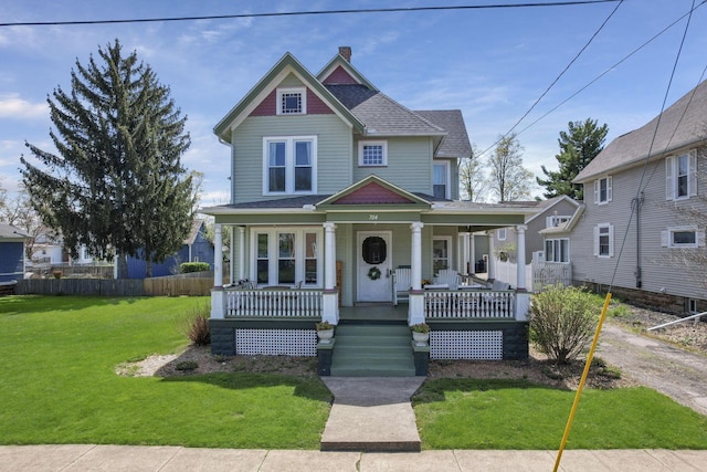 704 E High St, Mount Vernon, OH 43050 - victorian house with a front lawn, fence, a shingled roof, and covered porch