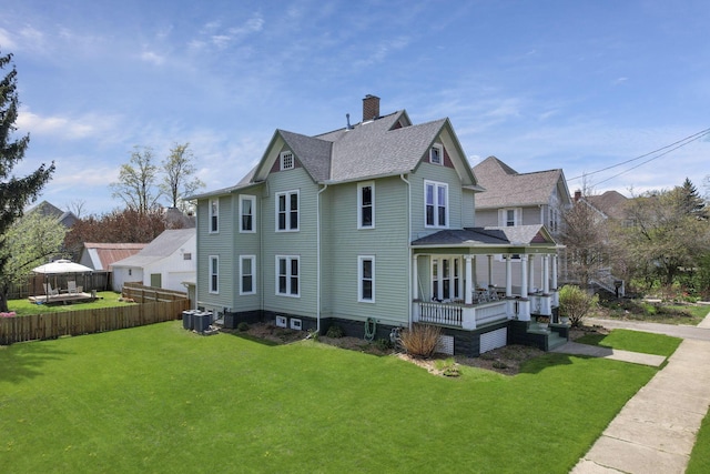 704 E High St, Mount Vernon, OH 43050 - view of property exterior featuring central AC, a chimney, fence, a shingled roof, and a yard