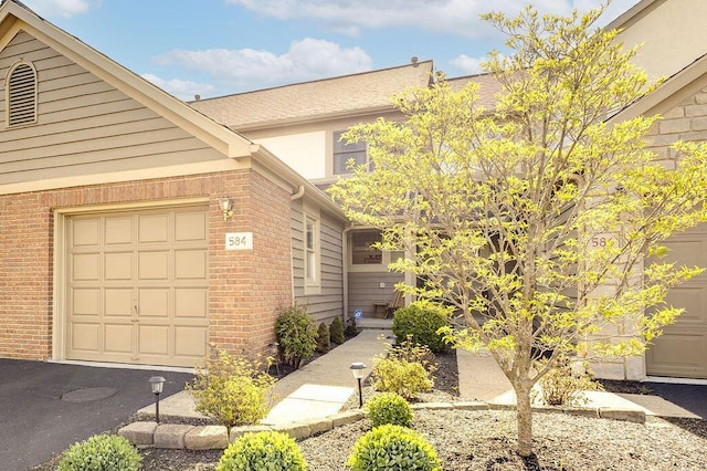 multi unit property with brick siding and an attached garage